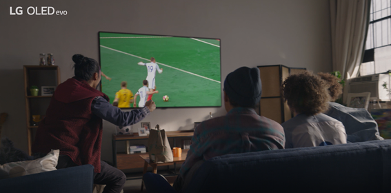  Four friends enjoying a game of football on LG OLED TV