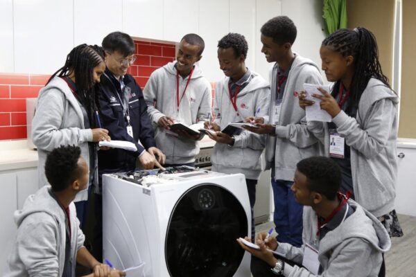 Young and eager Ethiopian trainees learning about LG Washer under the teacher's guidance