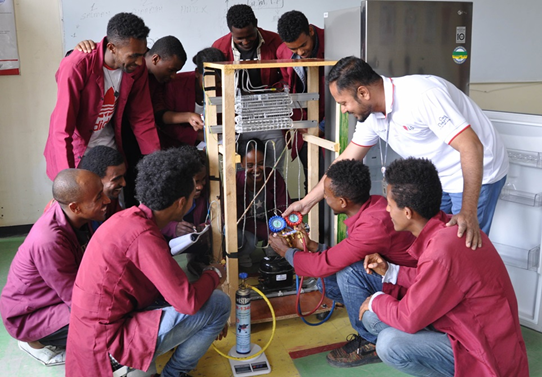 Young and eager Ethiopian trainees learning how to repair appliances under the teacher's guidance