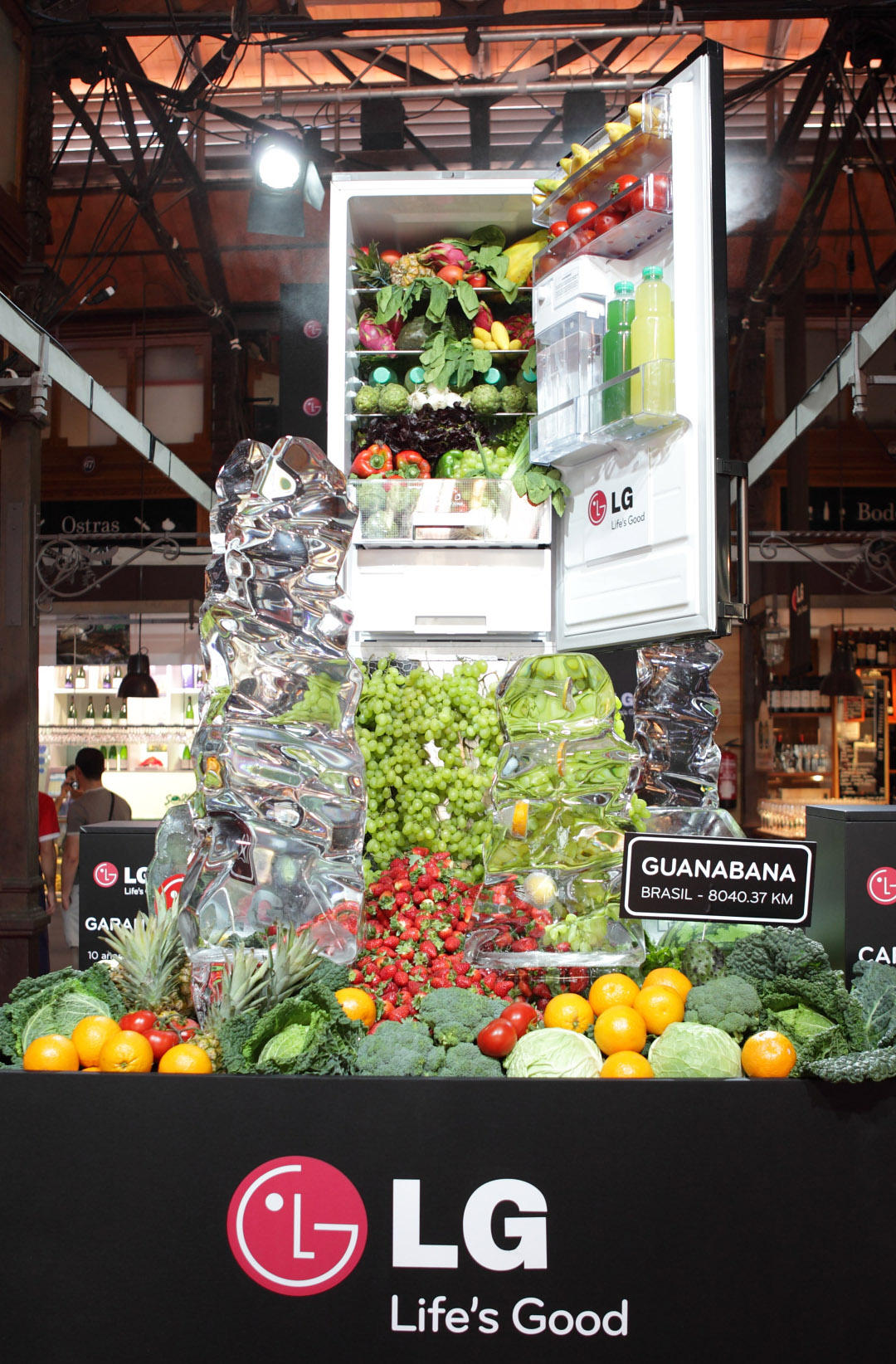 A giant-sized LG refrigerator display in…, with healthy fruits, vegetables and juices flowing from the appliance’s interior like a waterfall.