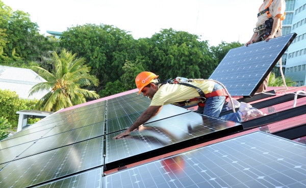 Mohamed Nasheed, president of the Maldives, helps install a solar panel on the president’s official residence, Mulee Aage Palace.