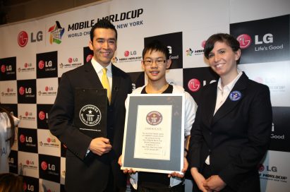 Cheong Kit Au from Australia, who set the Guinness World Record® for the fastest texting recorded on a QWERTY mobile phone device, poses with representatives of the Guinness World Records while holding his certificate