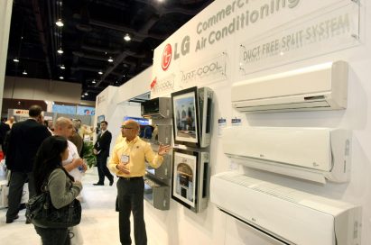 A man explains LG’s Duct Free Split System commercial air conditioners to visitors of the company's booth.