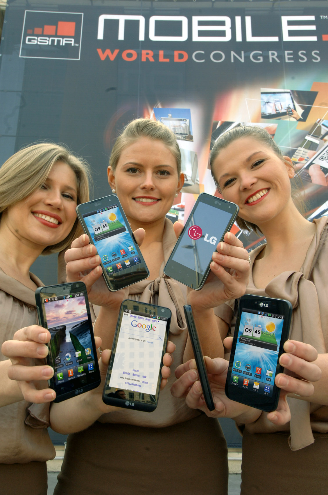 Three female models hold LG Optimus 3D, LG Optimus 2X and LG Optimus Black and show its front views at MWC 2011 event venue