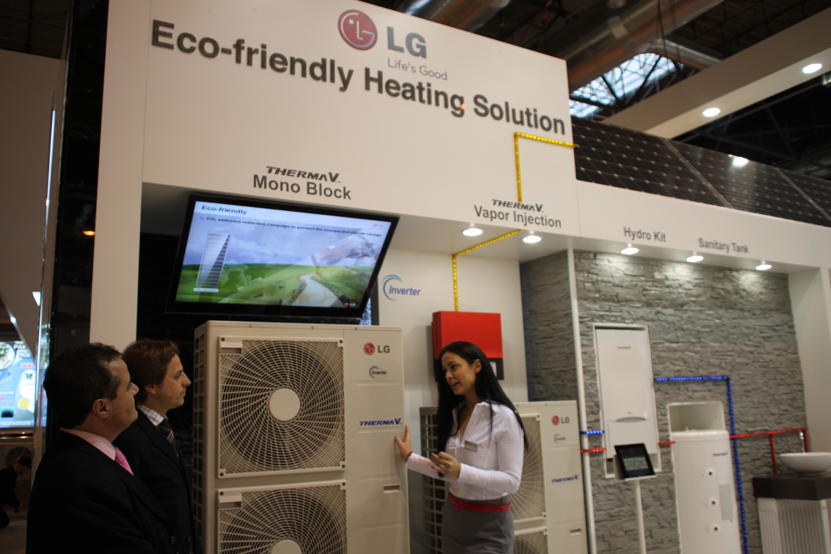 A woman explaining the LG THERMA V to a group of people