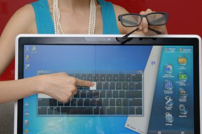 Marketing image of a model pointing at the touch screen of the LG ALL-IN-ONE PC