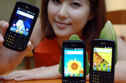 A model holds up LG Optimus Pro and shows its front view while LG Optimus Pro and LG Optimus Net are displayed in front of her