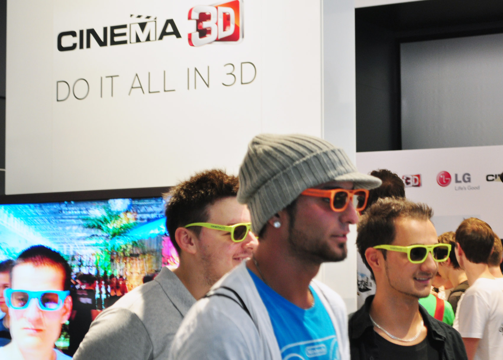 Three visitors wearing 3D glasses at the LG 3D Game Festival booth in Gamescom