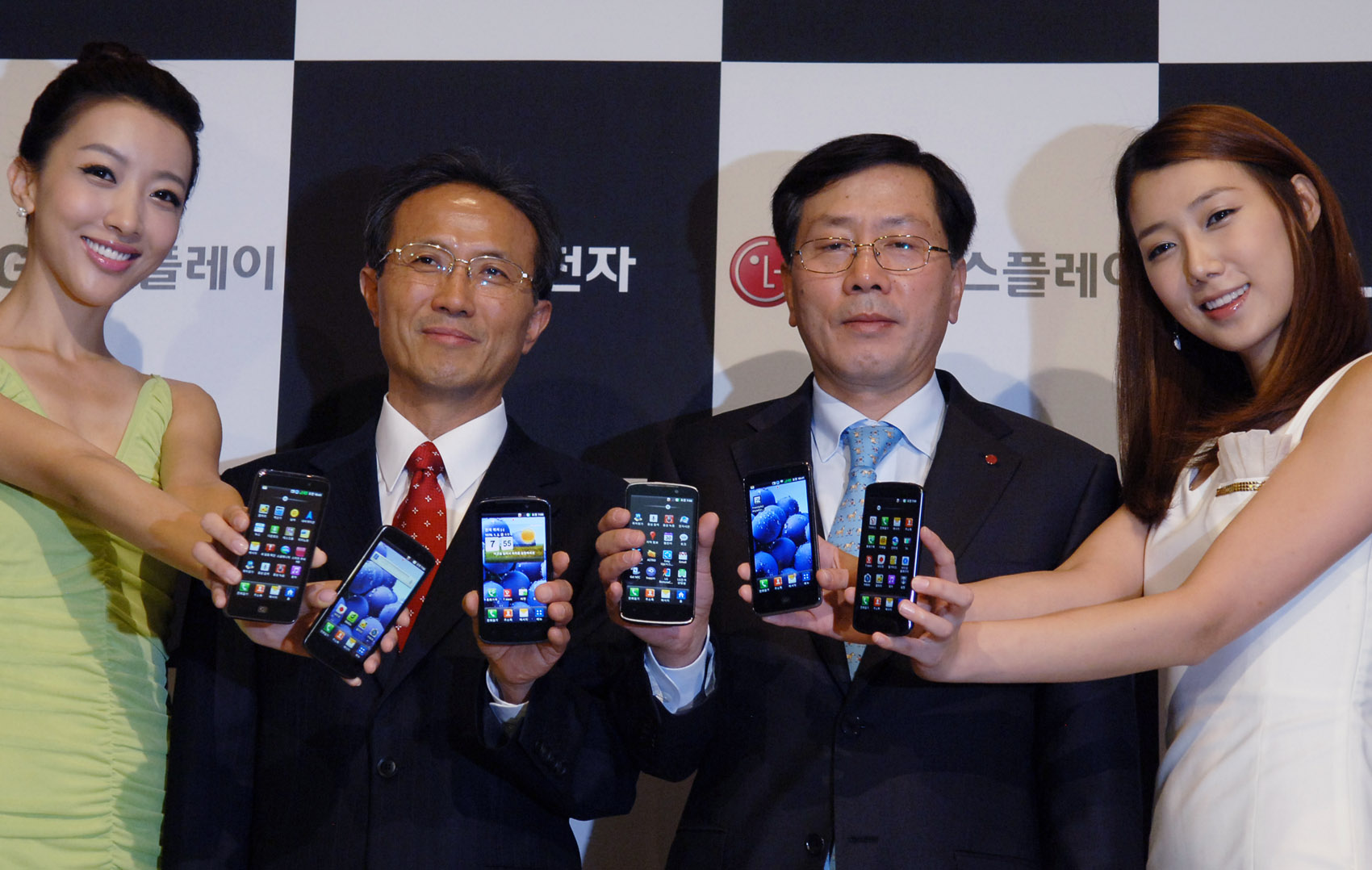 Sang-deok Yeo, Head of Mobile/OLED Department at LG Display, Young-bae, Na, Head of Business Marketing at LG Electronics Mobile Communication Company and two female models hold LG Optimus 3Ds and show its front views
