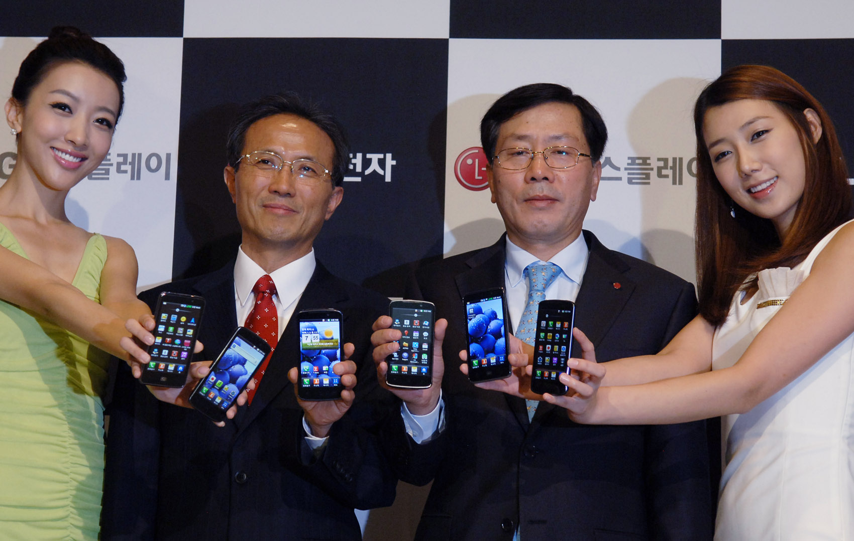 Sang-deok Yeo, Head of Mobile/OLED Department at LG Display, Young-bae, Na, Head of Business Marketing at LG Electronics Mobile Communication Company and two female models hold LG Optimus 3Ds and show its front views