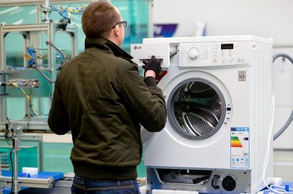 Another image that shows a staff member assembles washing machines on appliance production lines in Poland