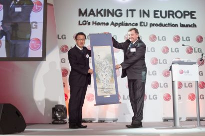 Two executives holding up a traditional Korean painting which shows white tiger at the launch event of LG's HA production facility in Poland.