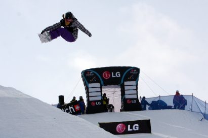 A snowboarder jumps above the LG Electronics stands