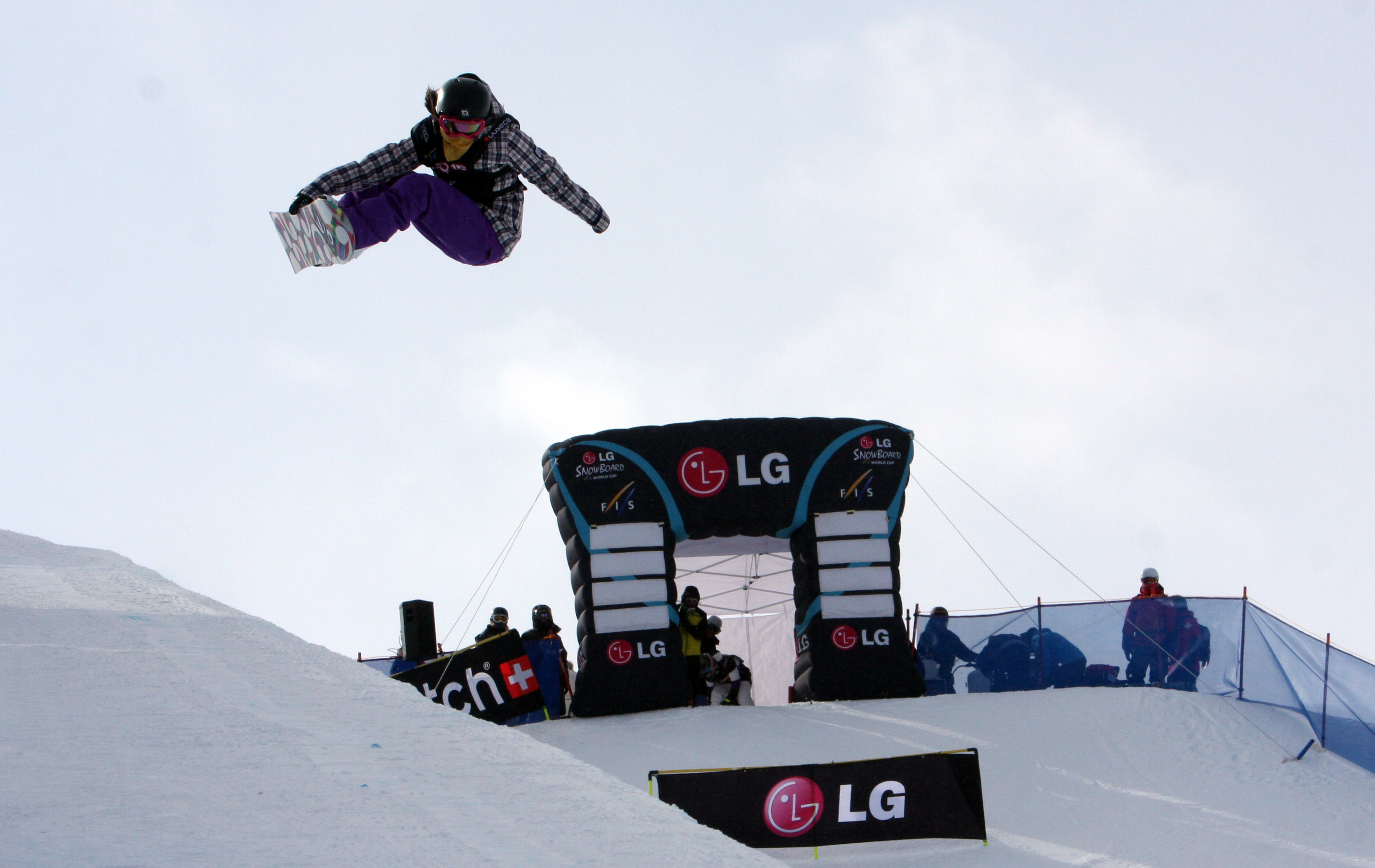 A snowboarder jumps above the LG Electronics stands