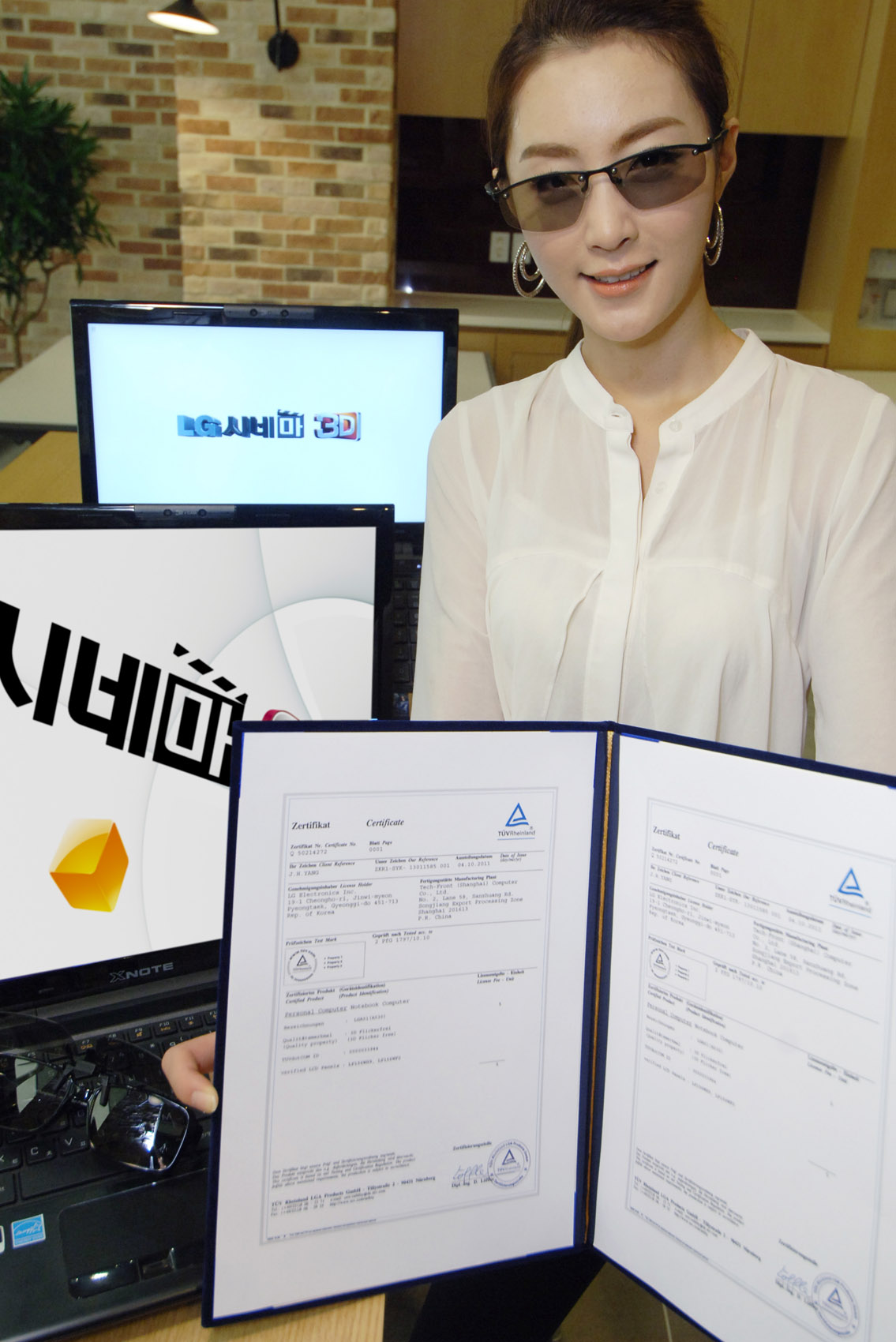 A model wearing 3D glasses while holding up the official TUV Rheinland certification letter of LG’s 3D Notebook