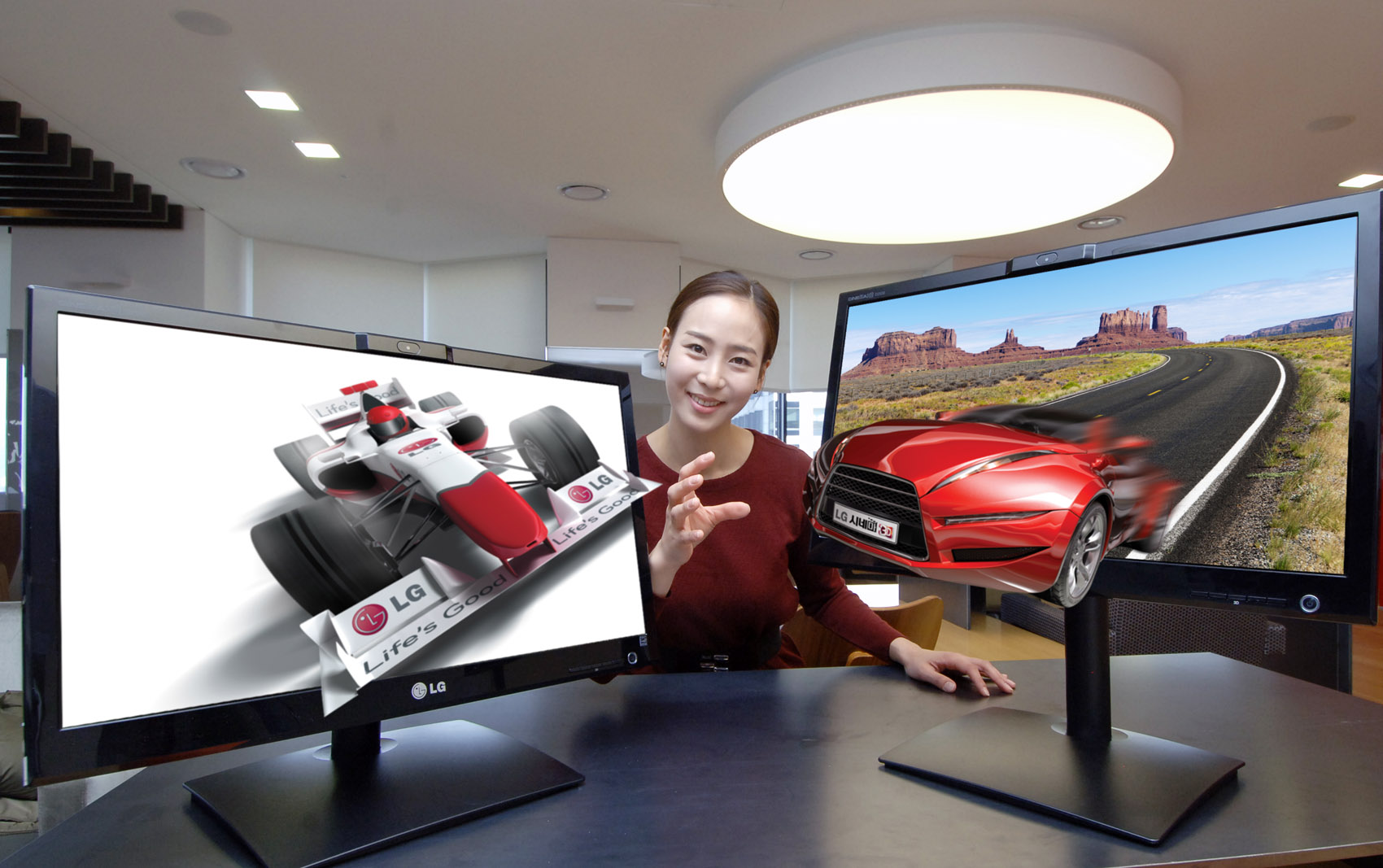 A model reaches out to grab 3D objects protruding out of LG’s 25-inch Glasses-Free 3D monitors