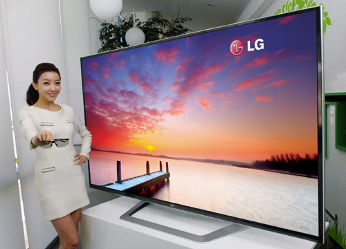 A model holding 3D glasses while showing off the world’s largest 84-inch 3D Ultra Definition TV.