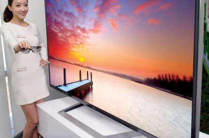 A model holding 3D glasses while showing off the world’s largest 84-inch 3D Ultra Definition TV