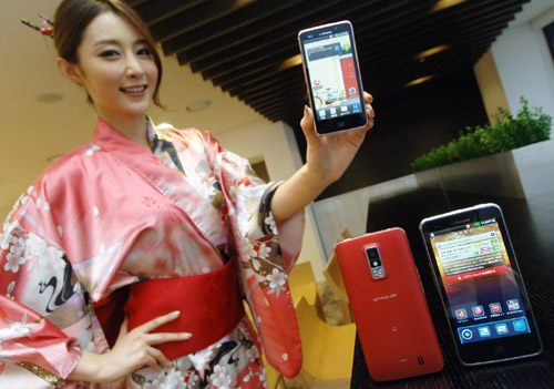 A woman in traditional Japanese clothing holds up LG Optimus LTE and shows its front view, while two LG Optimus LTEs showing front and rear views are displayed in front of her