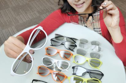 A model presenting the various types and colors of LG’s new 3D glasses lineup on a table