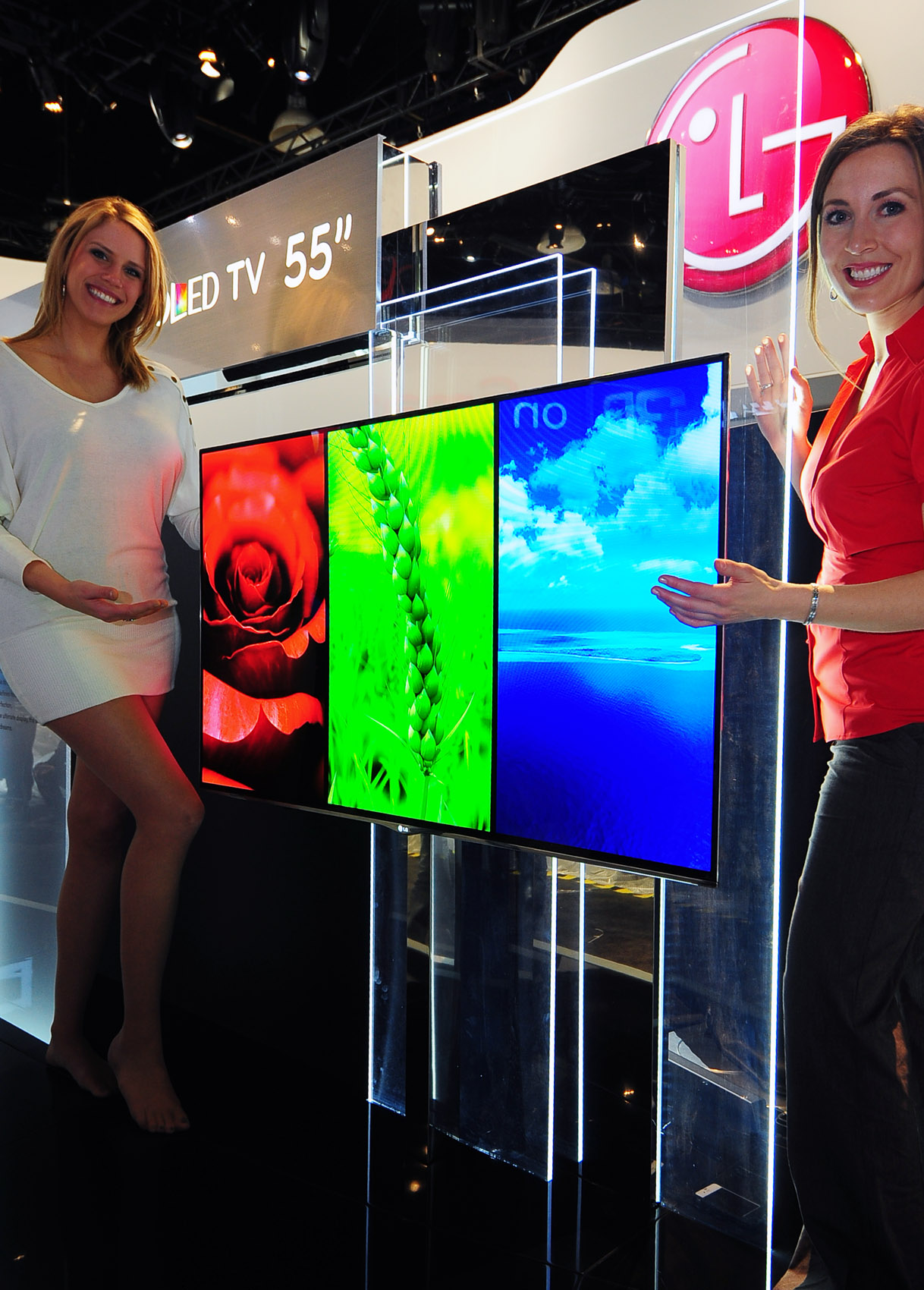 Two models present the 55-inch LG OLED TV at CES 2012