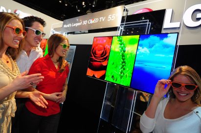Three visitors and a model wearing 3D glasses to experience LG’s 3D TVs at CES 2012