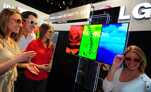Three visitors and a model wearing 3D glasses to experience LG’s 3D TVs at CES 2012.