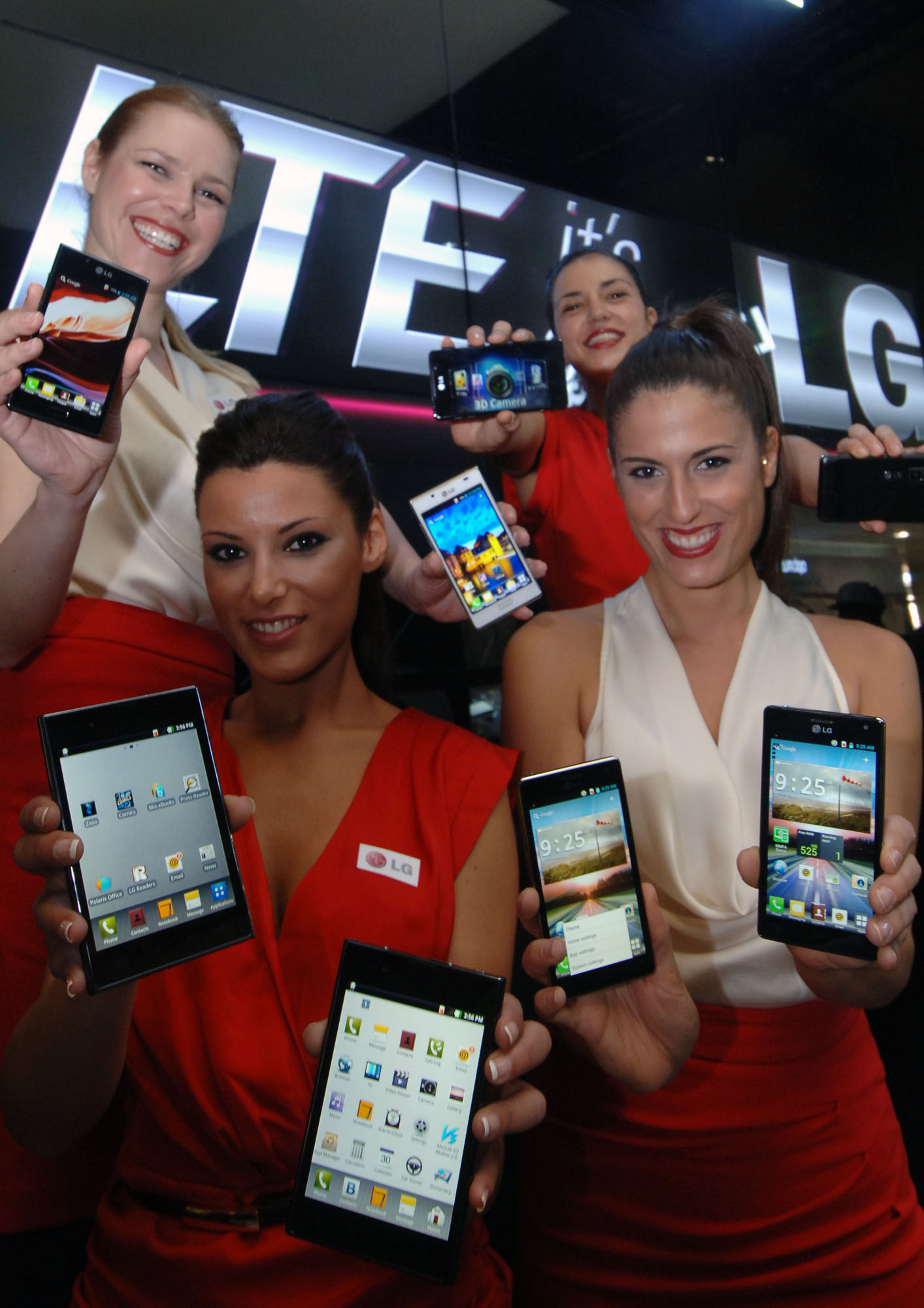4 female models hold LG Optimus Vu:, LG Optimus 4X HD, LG Optimus 3D Max and LG Optimus L7 and show its front and rear views at LG Booth