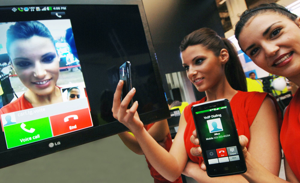 Two models try out the Voice to Video Convention feature on their LG mobile phones.