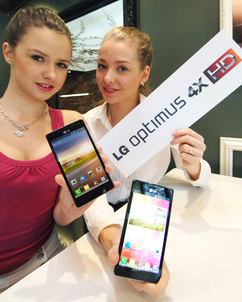 Two models hold up a LG Optimus 4X HD each while one also holds up the LG Optimus 4X HD logo in her other hand