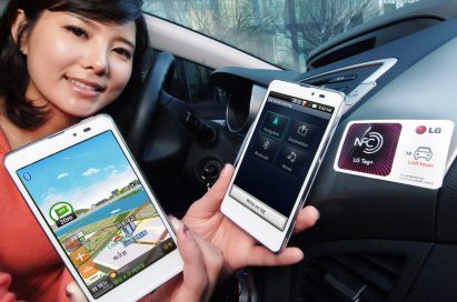 A woman holds two LG Optimus LTE Tags and shows their front views inside a car