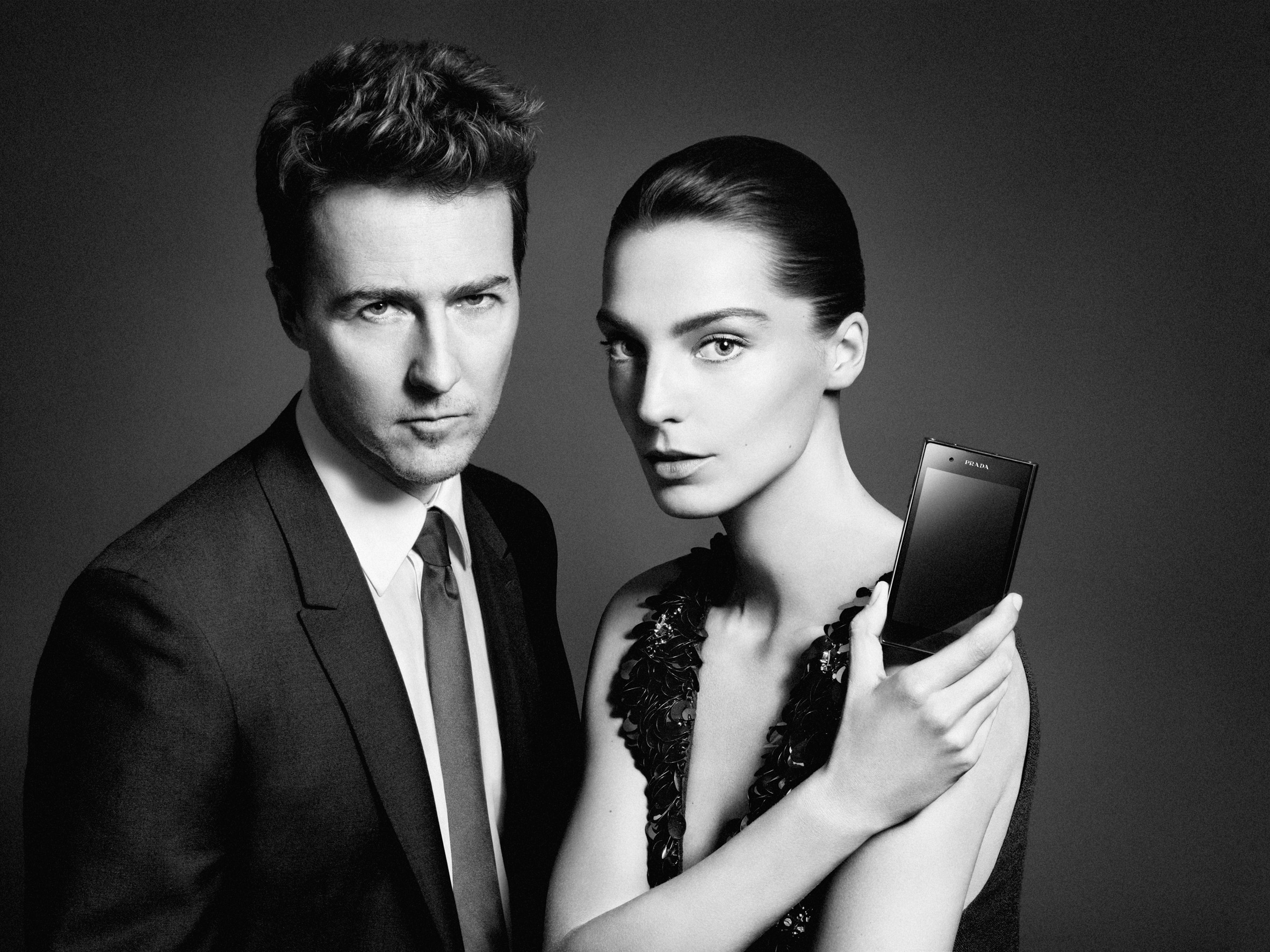 Daria Werbowy holds up the PRADA phone by LG 3.0 showing its front with Edward Norton