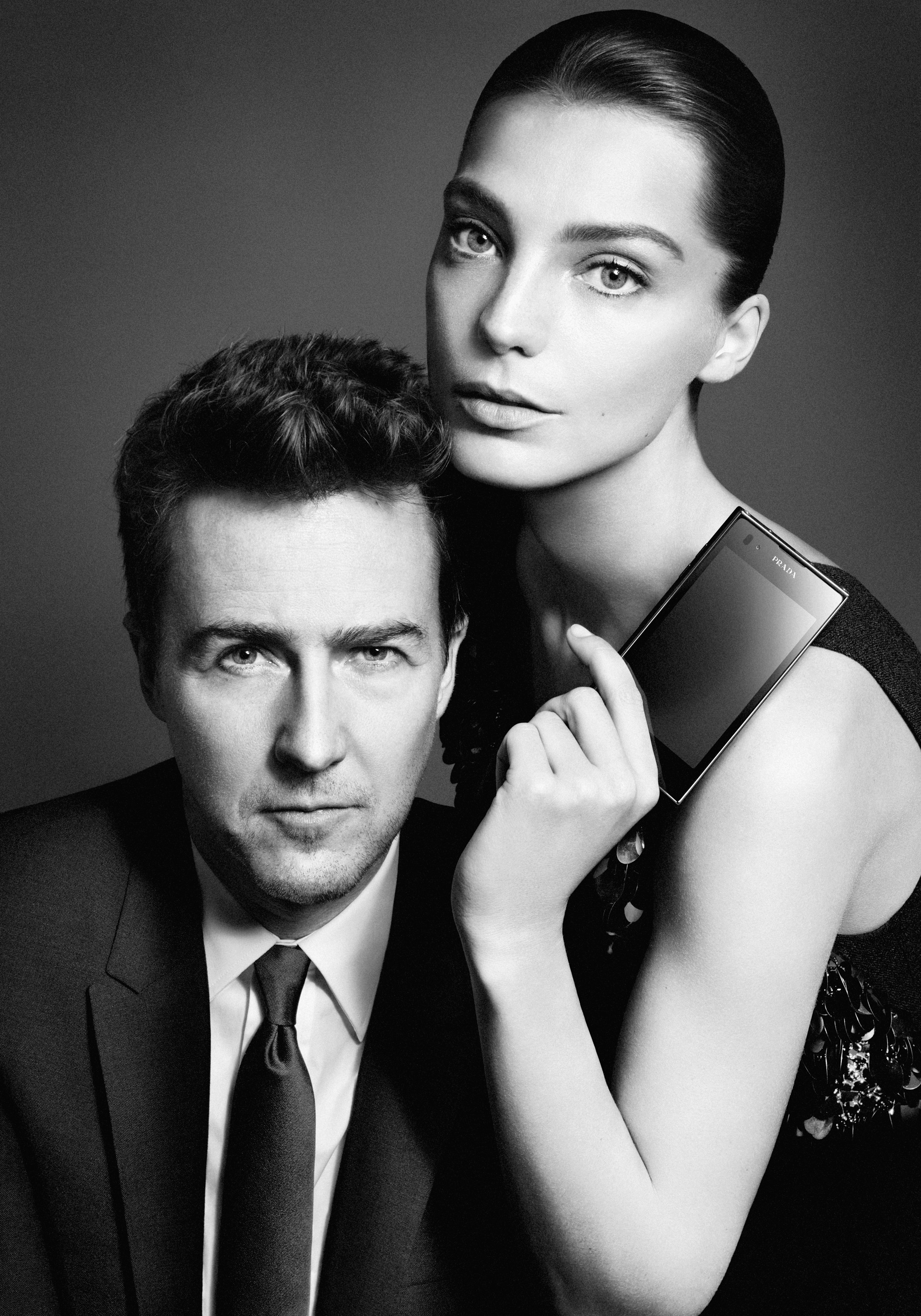 Daria Werbowy poses with Edward Norton while holding up the PRADA phone by LG 3.0 with its front showing