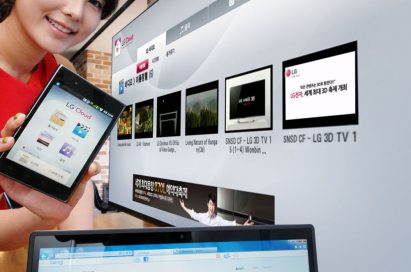 A female model holds up a phone displaying LG Cloud, the company's multimedia cloud platform on the screen while LG's XNote mirrors the phone’s screen.