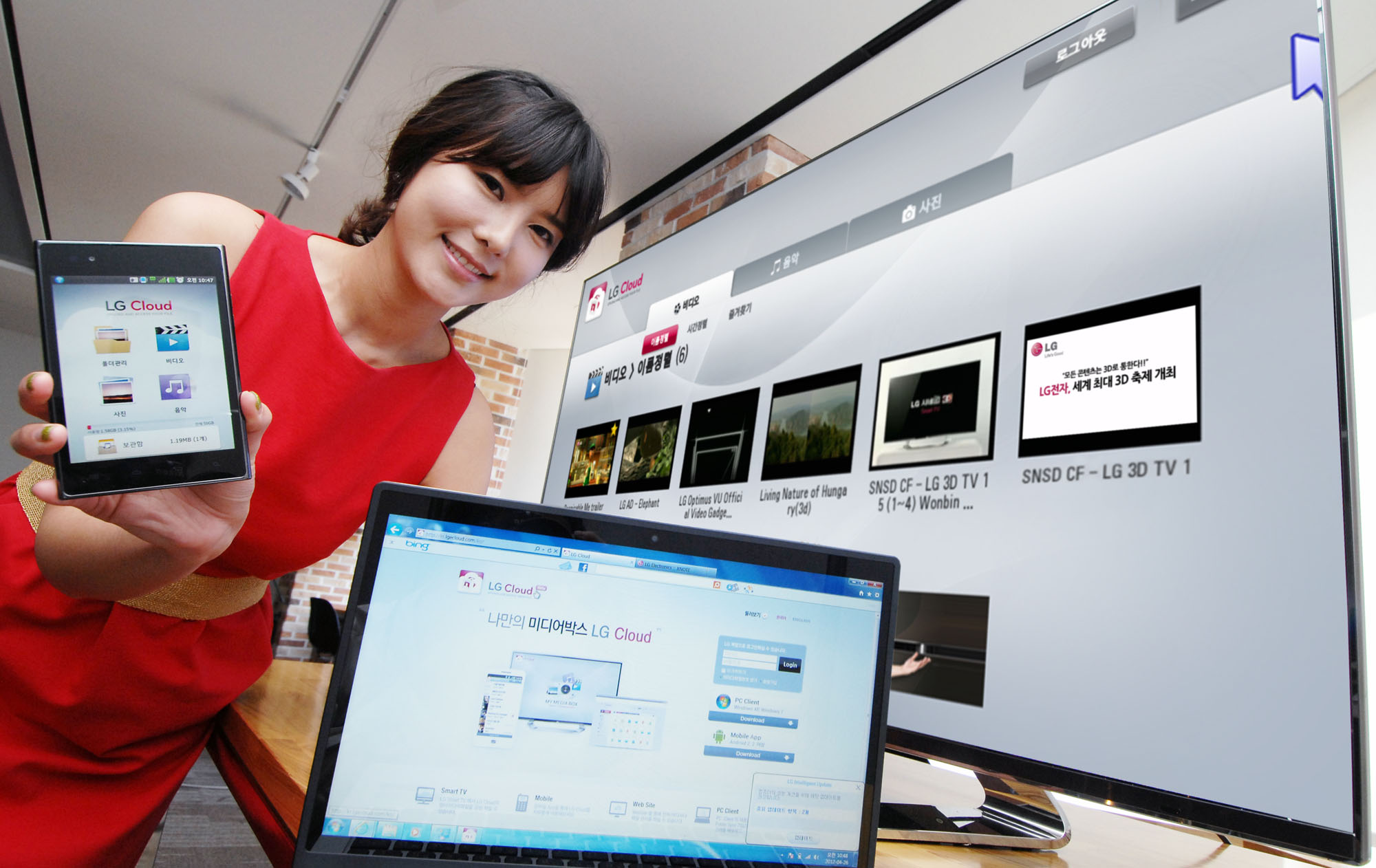 A model introduces the LG Cloud service which is compatible with TVs, mobile devices and PCs while standing up
