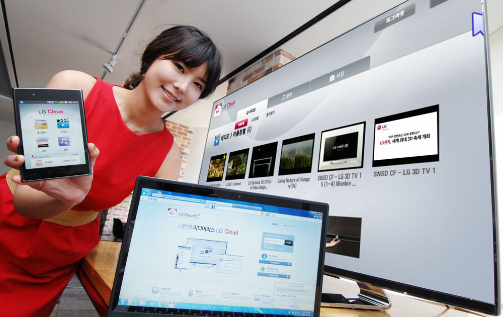 Another view of a female model holding up a phone displaying LG Cloud, the company's multimedia cloud platform on the screen while LG's XNote mirrors the phone’s screen