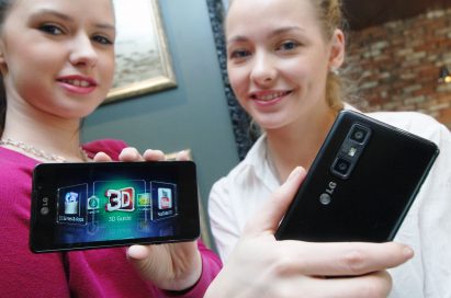 Two female models hold LG Optimus 3D Max and show its front and rear views