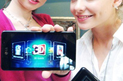 Two female models hold LG Optimus 3D Max and show its front and rear views
