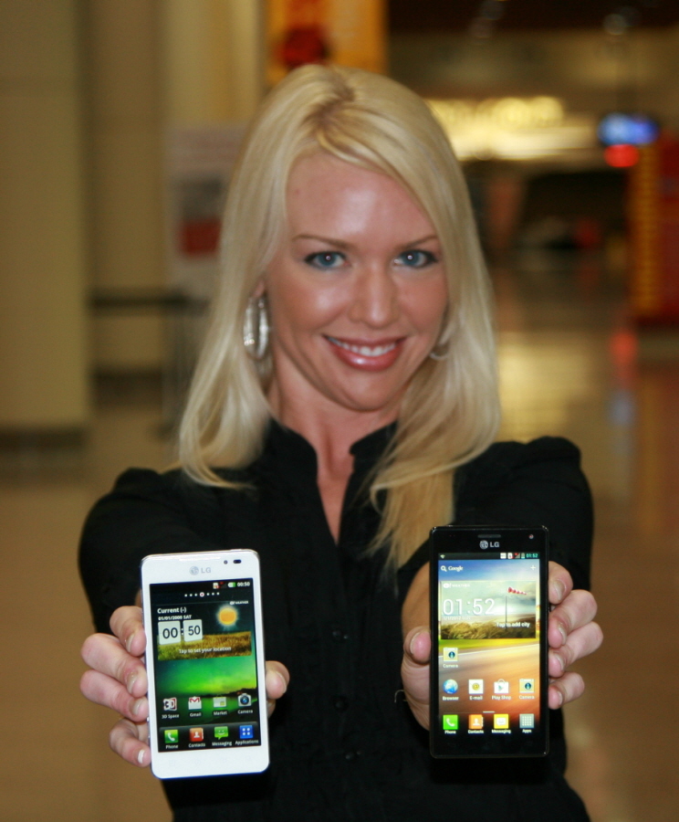 A female model holds white and black LG smartphones and shows its front views