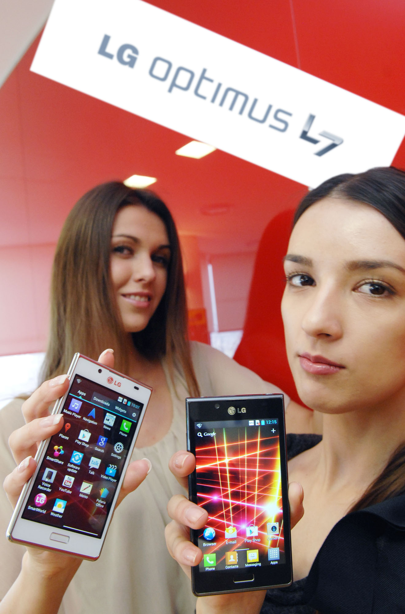 A third view of a model holding the white LG Optimus L7 while another holds the LG Optimus L7 and the LG Optimus L7 logo