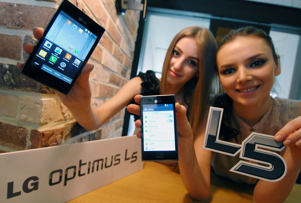 Two women each holding a stylish LG OPTIMUS L5