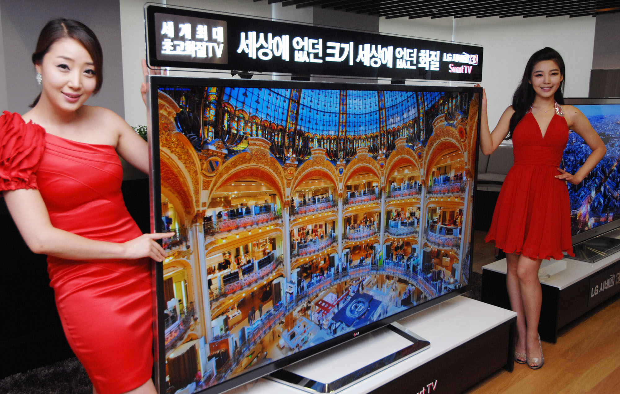 A side view of two models presenting the world’s first 84-inch Ultra Definition 3D TV by LG