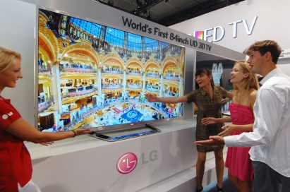 An LG booth staff member introducing the world’s first 84-inch UD 3D TV to visitors at IFA 2012