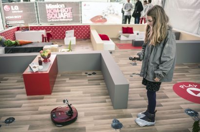 A lady controlling an LG HOM-BOT with its remote control at the LG HOM-BOT SQUARE launch event in France