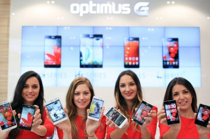 Four female models are smiling at a camera holding various strategic Optimus series devices at MWC 2013 - G, Vu:, F and LII.