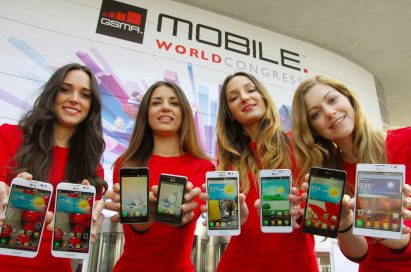 Four female models are smiling at a camera holding various strategic Optimus series devices at MWC 2013 - G, Vu:, F and LII.