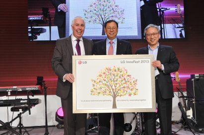 Seong-jin Jo, president and CEO of the LG Home Appliance Company, holds up the LG InnoFest 2013 slogan with two men at InnoFest 2013 in Berlin