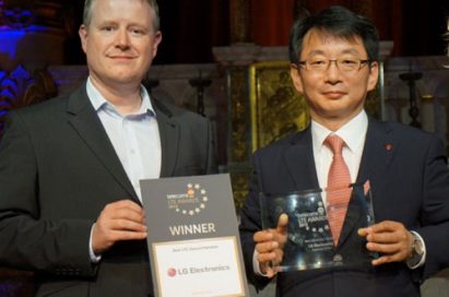 An official from telecom’s LTE AWARDS 2013 and an official from LG smiling at the camera while holding their awards.