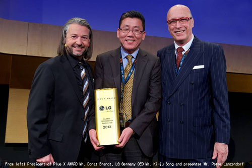 Song Ki-ju, CEO of LG Electronics Germany, holds the "Global Technology Innovator 2013" award while Donat Brandt, president of Plus X Award, and a presenter Peter Lanzendorf, stand next to him at the Plus X Award Night in Cologne, Germany