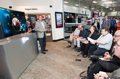 An LG representative demonstrates LG’s CURVED OLED TV model 55EA9800 to attendees